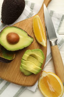 Lezzetli avokadolar, limon ve bıçak beyaz ahşap masa, düz uzanma