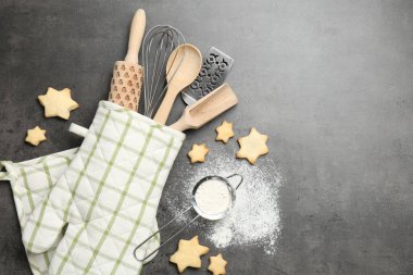 Farklı mutfak aletleri fırın eldiveninde, un ve kurabiyeler gri masada, düz yerde. Metin için boşluk