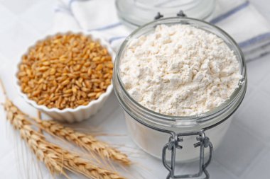 Buğday unu, tahıl ve çiviler beyaz fayanslı masada, yakın plan.