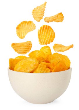 Lezzetli patates cipsleri beyaz arka planda kaseye düşüyor.