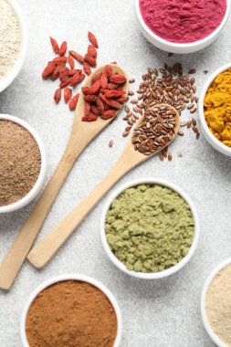 Açık gri masada farklı süper yiyecek tozları, düz yatıyordu.