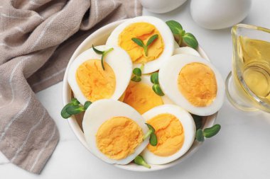 Beyaz masa üzerinde mikro yeşillik ve haşlanmış yumurtalardan oluşan yarımlar.