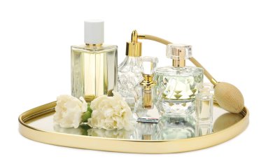 Birçok farklı parfüm şişeleri ve çiçekler beyaz üzerine izole edilmiş.