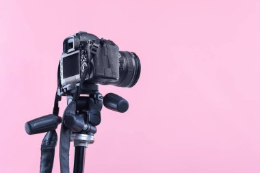 Pembe arka planda modern profesyonel kamera, alçak açılı görüntü. Metin için boşluk