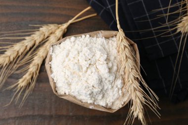 Tahta masanın üzerinde buğday unu ve çiviler var.