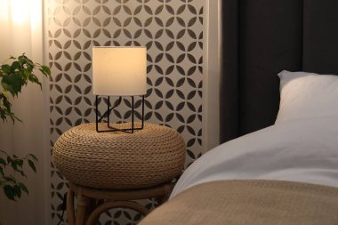 Yan masada yatağın yanında lamba var.