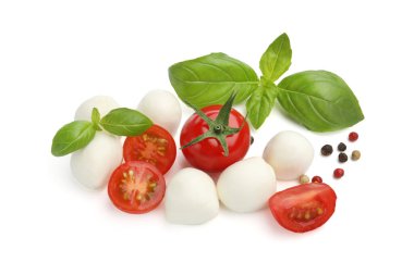 Lezzetli mozzarella peynirli toplar, domatesler, biberli mısır ve fesleğen beyaza izole edilmiş.