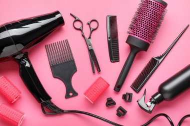 Pembe arka planda farklı kuaför aletleri, düz yatış