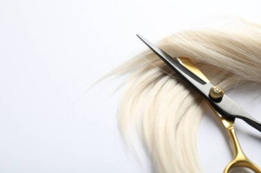 Beyaz arka planda saç tokası ve makas, üst tarafta. Metin için boşluk