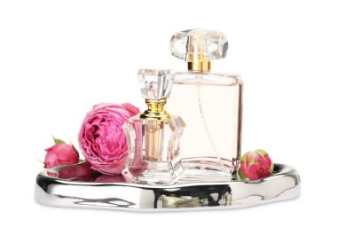 Farklı parfüm şişeleri ve beyaz güller.