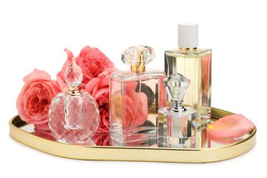 Birçok farklı parfüm şişeleri ve güller beyaz üzerine izole edilmiş.