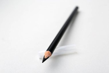 Açık arkaplanda siyah kaş kalemi, yakın plan. Metin için boşluk