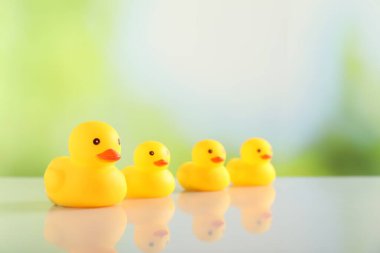 Masadaki sevimli plastik ördekler arka planda bulanık, yakın plan. Metin için boşluk