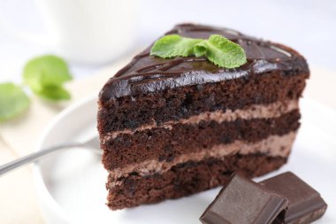 Nefis bir parça pasta, nane ve çikolata ışık masasında, yakın plan.