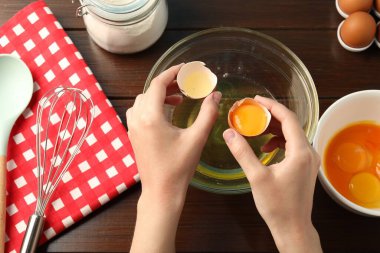 Tahta masada yumurta sarısını beyazdan ayıran kadın.