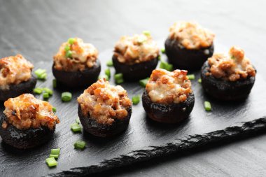 Siyah masada servis edilen lezzetli mantarlar, yakın plan.