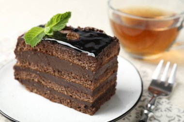Nane, çatal ve çayla servis edilen çikolatalı kek.