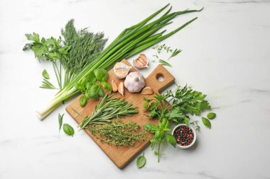 Farklı taze otlar ve baharatlar beyaz mermer masada, düz yatıyordu.