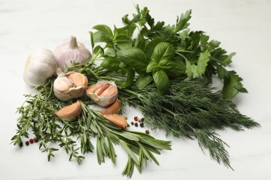 Beyaz masada farklı taze otlar ve baharatlar.