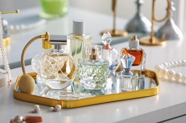 Beyaz masadaki farklı parfümlerden şişeler, yakın plan.