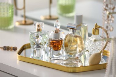 Beyaz masadaki farklı parfümlerden şişeler, yakın plan.