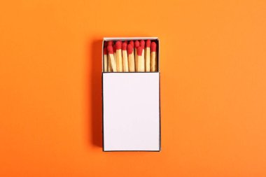 Turuncu arka plandaki kutuda kibrit, üst manzara. Tasarım için model