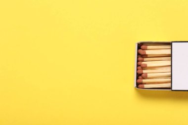 Sarı arka planda kutuda kibrit var, en üstte. Metin için boşluk