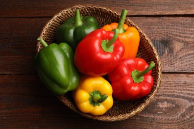 Taze renkli dolmalık biberler hasır sepetin içinde ahşap masanın üstünde, üst tarafta.