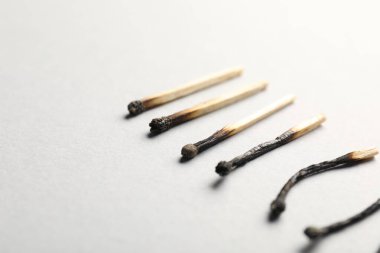 Açık gri arkaplanda yanmış kibritler, yakın plan