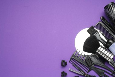 Mor arka planda farklı kuaför aletleri, düz yatış. Metin için boşluk
