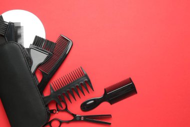 Kırmızı arka planda farklı kuaför aletleri var. Metin için boşluk