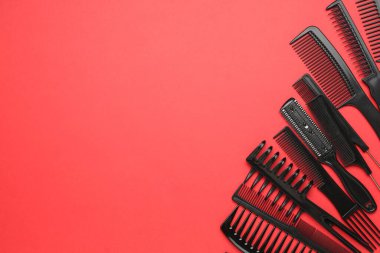 Kırmızı arka planda farklı kuaför aletleri var. Metin için boşluk