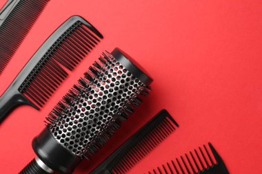 Kırmızı arka planda farklı kuaför aletleri var. Metin için boşluk