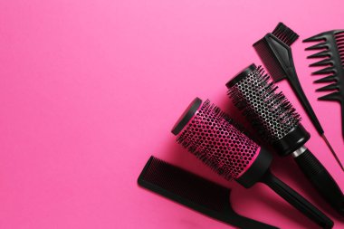 Pembe arka planda farklı kuaför aletleri, düz yatış. Metin için boşluk