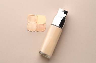 Renkli cilt temelleri ve gri arka planda şişe, düz yatıyordu