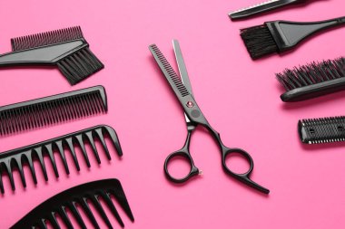 Pembe arka planda farklı kuaför aletleri.