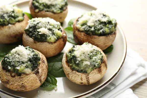 Hafif ahşap masada servis edilen lezzetli mantarlar, yakın plan.