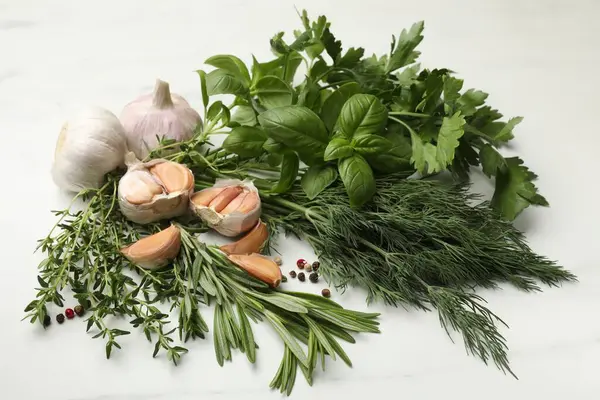 Beyaz masada farklı taze otlar ve baharatlar.