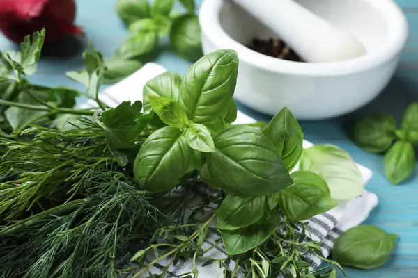 Mavi ahşap masada farklı otlar ve baharatlar, yakın plan.