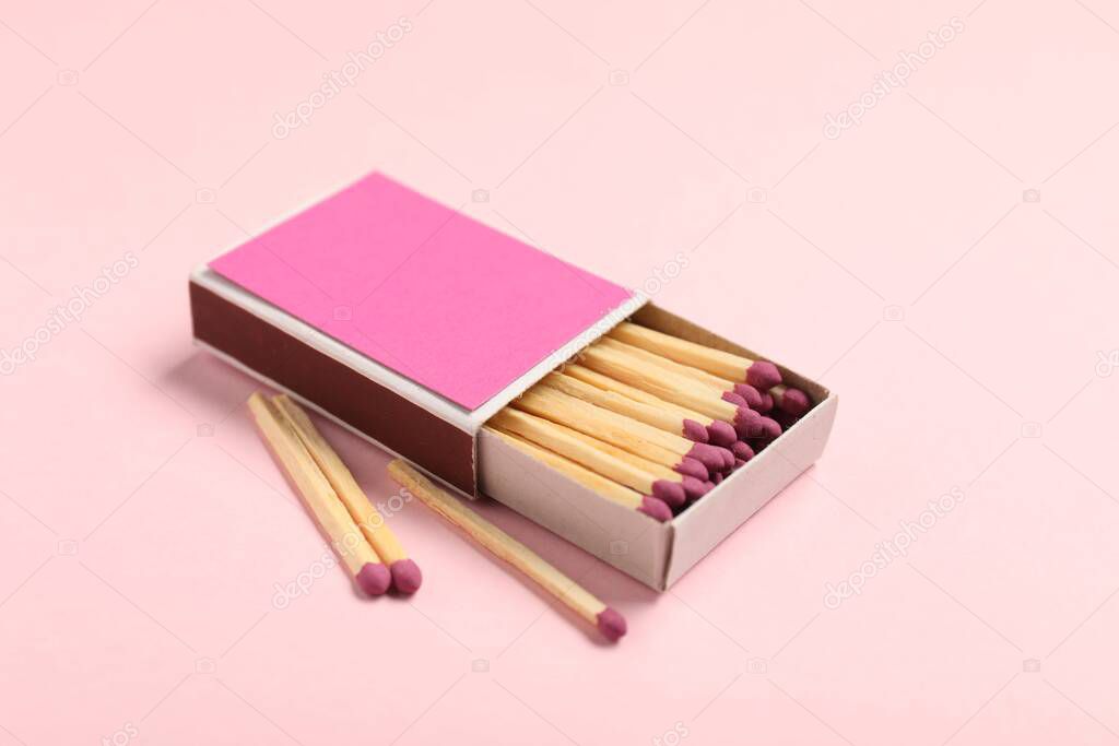 Matches and box on pink background, closeup