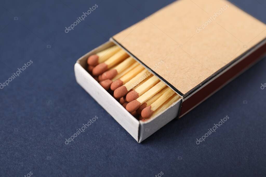 Matches in box on blue background, closeup. Mockup for design