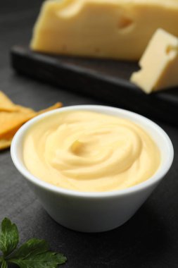 Lezzetli peynir sosu siyah masada, yakın plan.