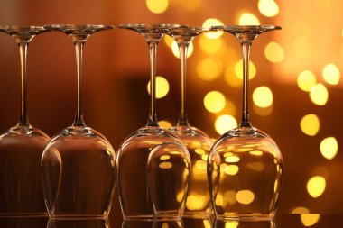 Bulanık ışıklara karşı cam ayna yüzeyinde birçok temiz bardak var. Bokeh etkisi