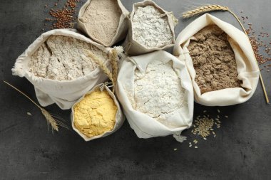 Gri masadaki poşetlerdeki farklı un türleri, düz yatıyordu.