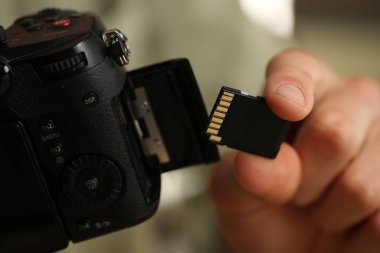 SD bellek kartını fotoğraf makinesine yerleştiren adam, kapat