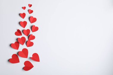 Açık gri arkaplanda bir sürü kağıt kalp, düz bir zemin. Metin için boşluk