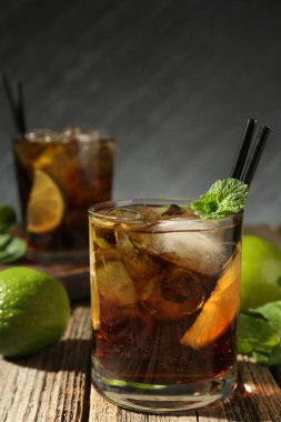 Küba libre kokteylini ahşap masada nane şekeriyle tazeliyorum. Metin için boşluk