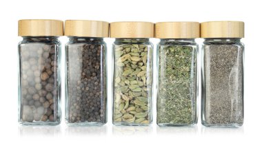 Beyaz kavanozlardaki farklı aromatik baharatlar.