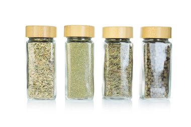 Beyaz kavanozlardaki farklı aromatik baharatlar.