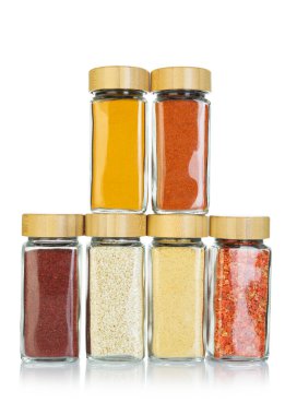 Beyaz kavanozlardaki farklı aromatik baharatlar.